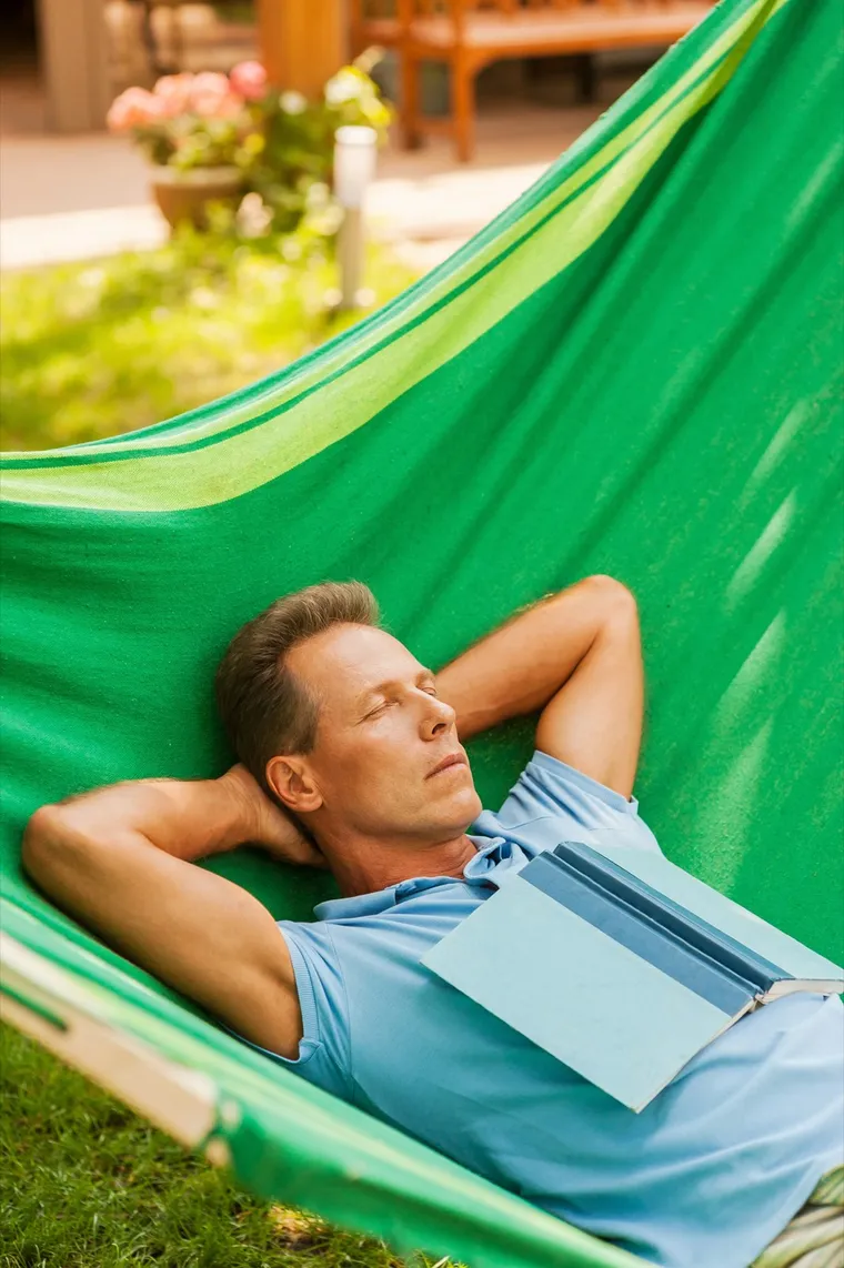 A man resting outdoors in a hammock