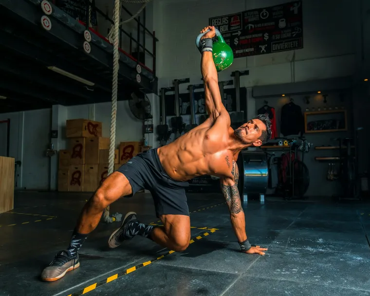 An active adult training with a kettlebell in a gym